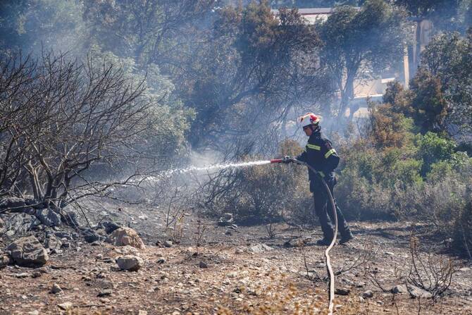 Firefighters in Greece struggle to save coastal resort as winds rage