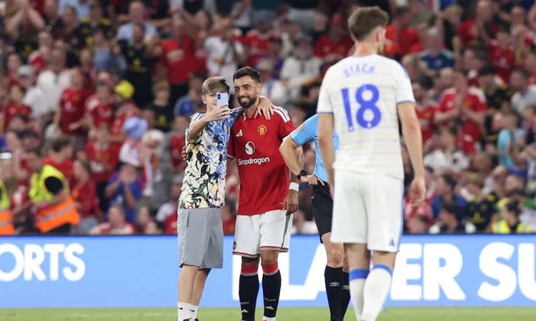 Pitch invaders take selfies with Fernandes during Man Utd friendly